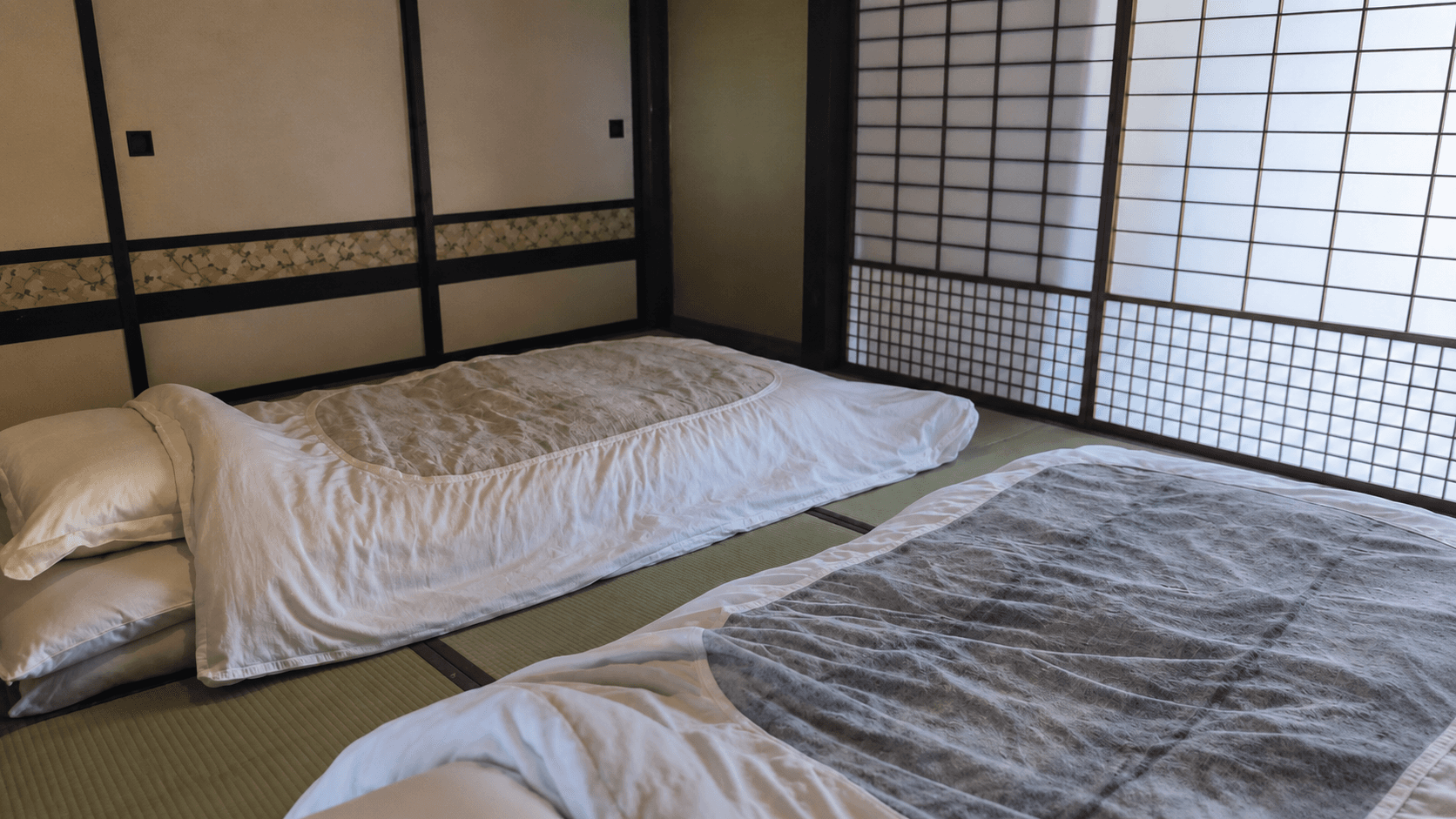 障子から光が入る畳の間に二組の寝具を整えた風山舎の和室